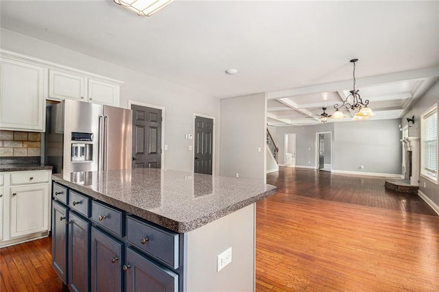 kitchen featuring stainless steel refrigerator with ice dispenser, dark wood finished floors, a kitchen island, ceiling fan, and open floor plan