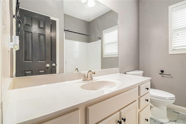 full bath featuring toilet, vanity, a shower, and baseboards