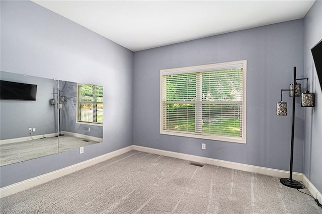 carpeted spare room with baseboards
