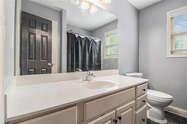bathroom with toilet, baseboards, vanity, and a shower with curtain