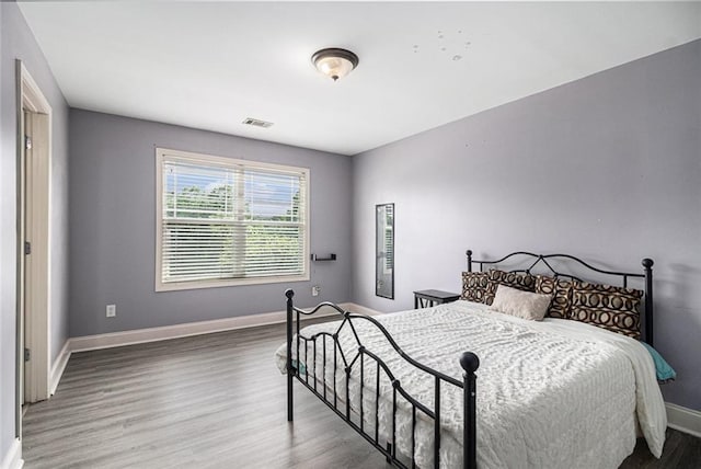 bedroom featuring baseboards and wood finished floors