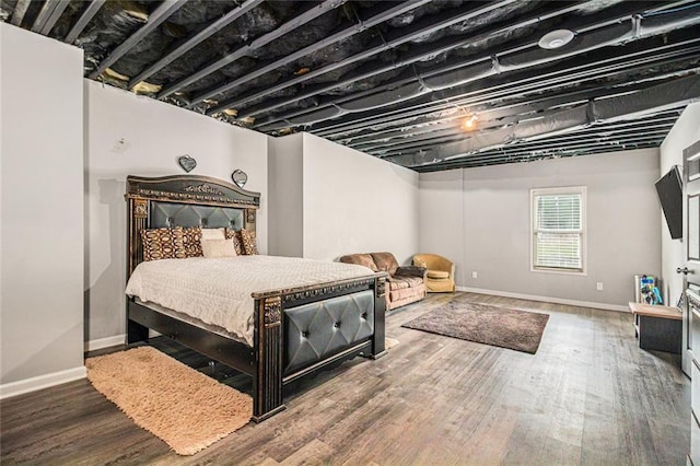 bedroom with wood finished floors and baseboards