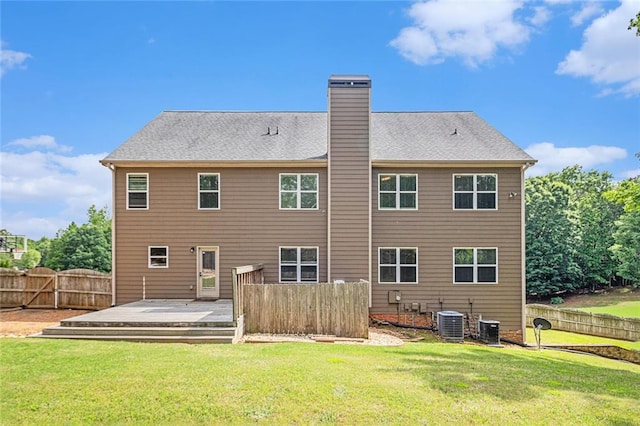 rear view of house featuring a deck, a chimney, and central AC unit