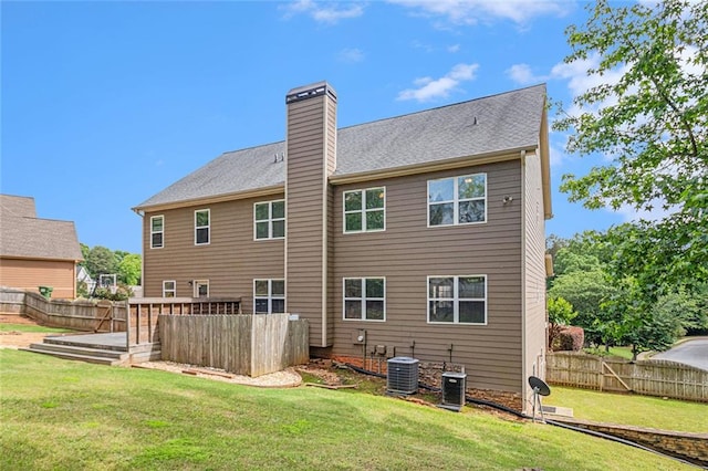 back of property with a chimney and central air condition unit