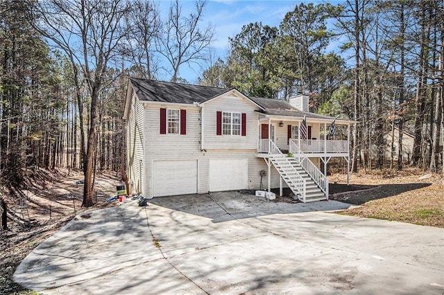 view of front of property with driveway, a chimney, stairway, an attached garage, and a porch