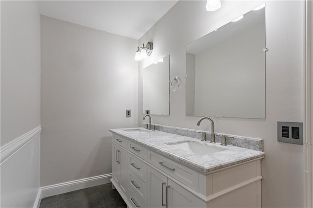 bathroom featuring double vanity, a sink, and baseboards