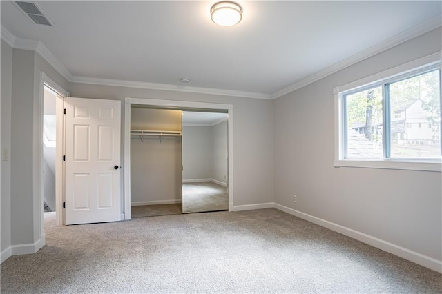 unfurnished bedroom with a closet, carpet, ornamental molding, baseboards, and visible vents