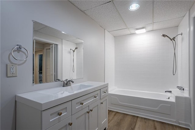 bathroom featuring wood finished floors, a paneled ceiling, shower / washtub combination, and vanity