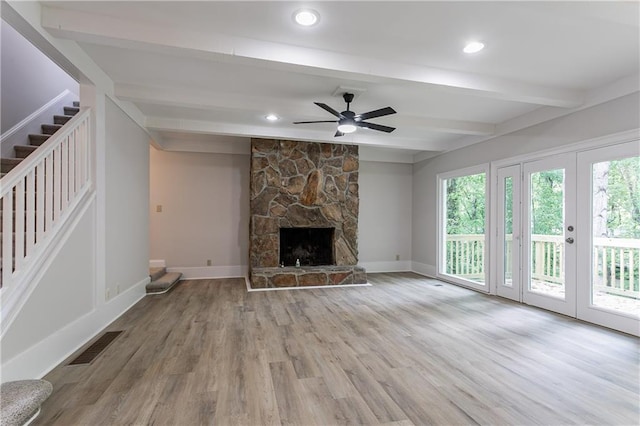 unfurnished living room featuring stairs, visible vents, beam ceiling, and plenty of natural light