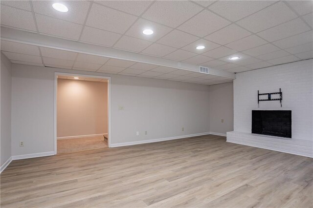 unfurnished living room with recessed lighting, light wood-type flooring, a brick fireplace, baseboards, and visible vents