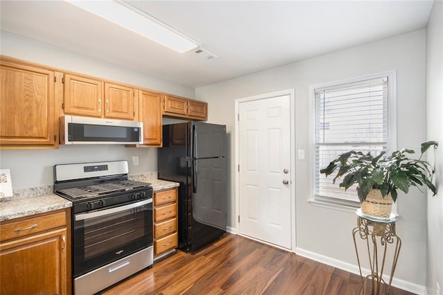 kitchen featuring stainless steel appliances and dark hardwood / wood-style floors