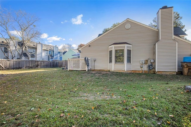 rear view of property featuring a lawn