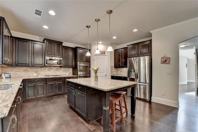 4191 Secret Shoals Way, Buford, GA 30518 - kitchen featuring stainless steel appliances, dark brown cabinets, a center island, dark wood finished floors, and backsplash