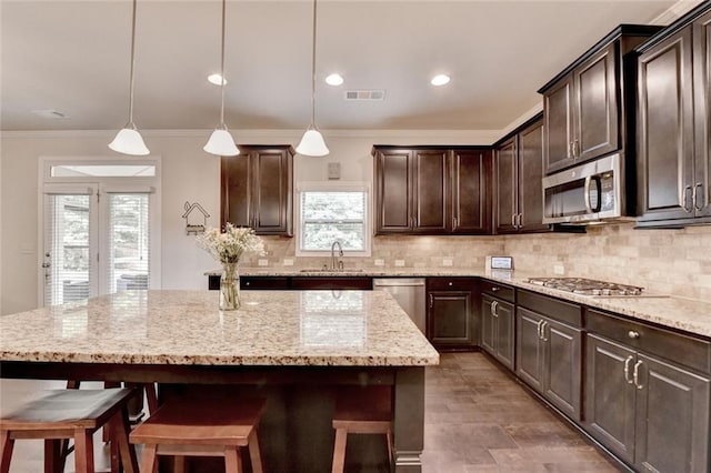 4191 Secret Shoals Way, Buford, GA 30518 - kitchen with appliances with stainless steel finishes, a sink, tasteful backsplash, dark brown cabinets, and a kitchen breakfast bar
