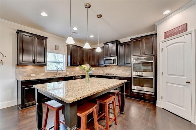 4191 Secret Shoals Way, Buford, GA 30518 - kitchen featuring stainless steel appliances, dark wood-style flooring, a breakfast bar, dark brown cabinetry, and crown molding