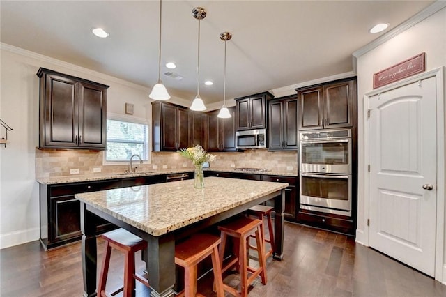 4191 Secret Shoals Way, Buford, GA 30518 - kitchen featuring stainless steel appliances, dark wood-style flooring, dark brown cabinetry, a kitchen breakfast bar, and crown molding