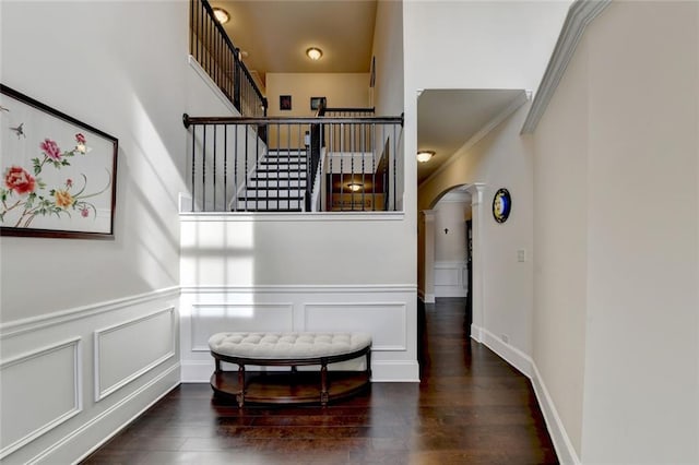 4191 Secret Shoals Way, Buford, GA 30518 - staircase featuring arched walkways, wood finished floors, wainscoting, a decorative wall, and crown molding