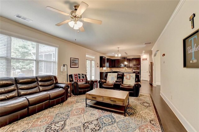 4191 Secret Shoals Way, Buford, GA 30518 - living area featuring ceiling fan, ornamental molding, baseboards, wood finished floors, and arched walkways