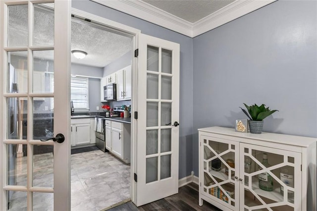 interior space with crown molding, wood-type flooring, a textured ceiling, and french doors