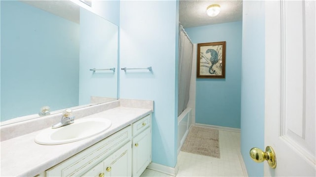 bathroom featuring vanity, shower / bathtub combination with curtain, and a textured ceiling