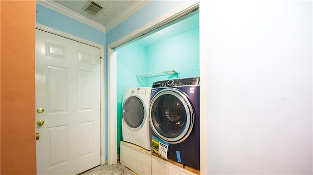 laundry area with crown molding and washing machine and clothes dryer