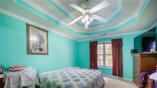 carpeted bedroom with a raised ceiling, crown molding, and ceiling fan