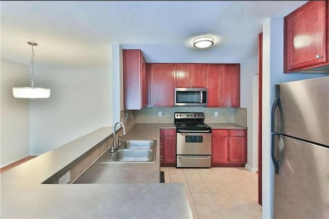 kitchen featuring pendant lighting, backsplash, sink, light tile patterned floors, and stainless steel appliances