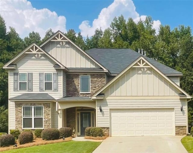 craftsman house with concrete driveway, stone siding, an attached garage, a front lawn, and board and batten siding