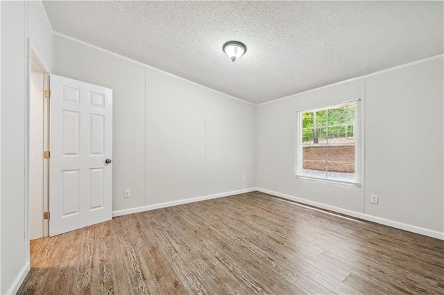 6670 George Ct, Cumming, GA 30041 - spare room featuring wood finished floors, a textured ceiling, crown molding, and baseboards
