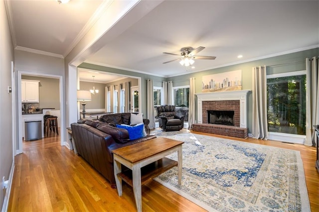1304 Carrington Way, Lawrenceville, GA 30044 - living area with healthy amount of natural light, light wood-type flooring, a brick fireplace, ceiling fan, and crown molding