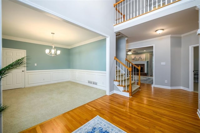 1304 Carrington Way, Lawrenceville, GA 30044 - foyer entrance featuring wood finished floors, stairway, a chandelier, a wainscoted wall, and crown molding