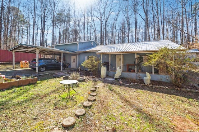 view of front of property featuring a sunroom, an attached carport, and metal roof