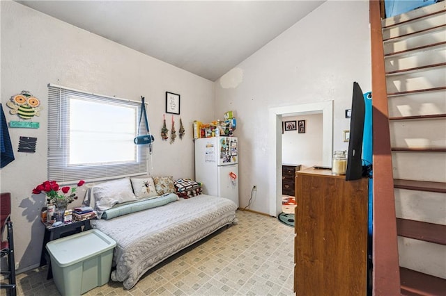 bedroom with freestanding refrigerator and vaulted ceiling
