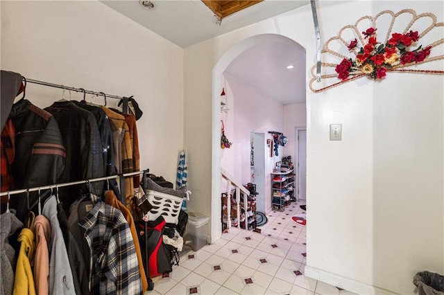 spacious closet with tile patterned flooring and arched walkways