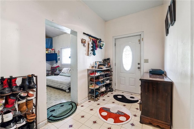 foyer entrance with light tile patterned floors and a healthy amount of sunlight