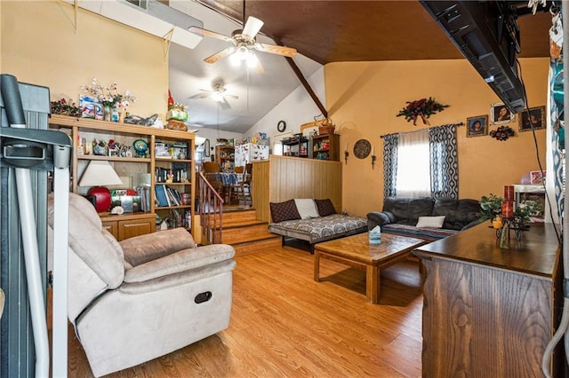 living room featuring a ceiling fan, stairs, wood finished floors, and vaulted ceiling