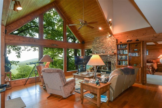 1115 Wild Turkey Blf, Jasper, GA 30143 - living room featuring high vaulted ceiling, wooden walls, a fireplace, wood finished floors, and ceiling fan