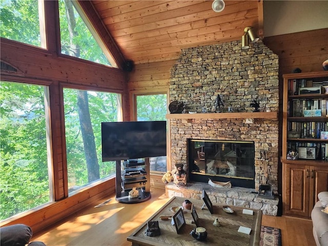 1115 Wild Turkey Blf, Jasper, GA 30143 - living area with wood finished floors, a stone fireplace, vaulted ceiling, and wooden walls