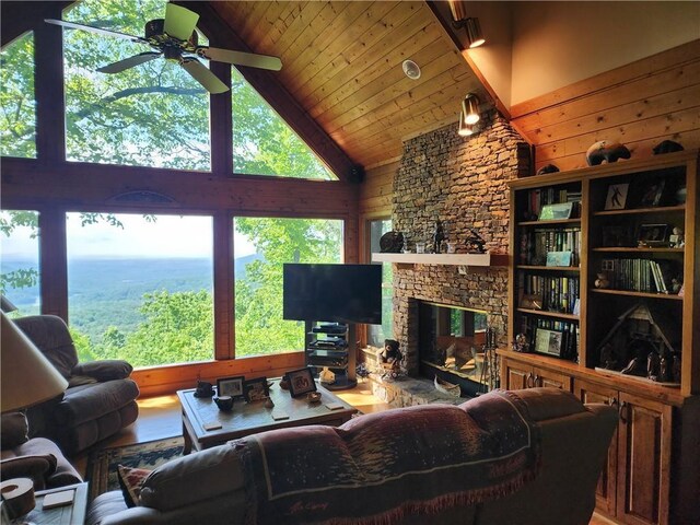 1115 Wild Turkey Blf, Jasper, GA 30143 - living area with a ceiling fan, high vaulted ceiling, a fireplace, wood walls, and wood finished floors