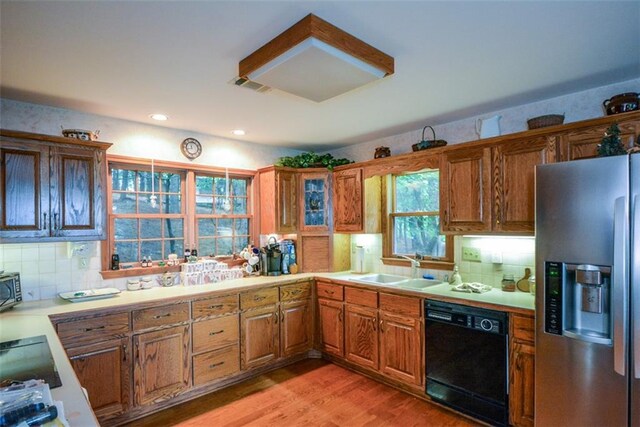 1115 Wild Turkey Blf, Jasper, GA 30143 - kitchen with stainless steel fridge with ice dispenser, black dishwasher, brown cabinetry, tasteful backsplash, and light wood-style floors
