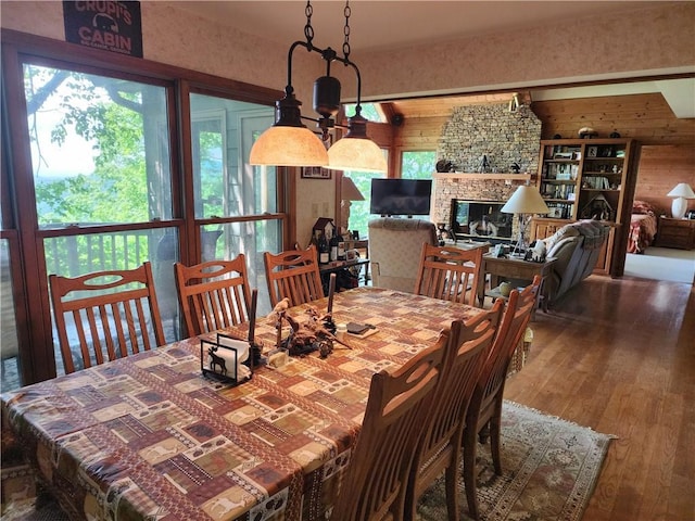 1115 Wild Turkey Blf, Jasper, GA 30143 - dining room featuring wood walls, hardwood / wood-style floors, and a stone fireplace