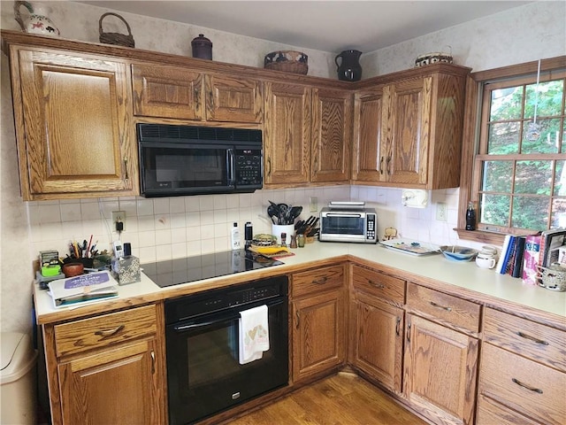 1115 Wild Turkey Blf, Jasper, GA 30143 - kitchen featuring black appliances, backsplash, light wood finished floors, light countertops, and brown cabinets