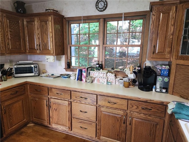 1115 Wild Turkey Blf, Jasper, GA 30143 - kitchen featuring light countertops, brown cabinets, glass insert cabinets, dark wood-type flooring, and backsplash
