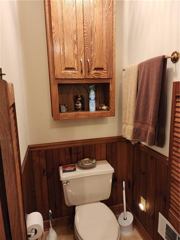 1115 Wild Turkey Blf, Jasper, GA 30143 - half bathroom with a wainscoted wall, toilet, and wooden walls