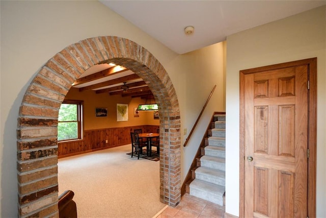 1115 Wild Turkey Blf, Jasper, GA 30143 - staircase featuring arched walkways, carpet floors, a wainscoted wall, wooden walls, and tile patterned floors