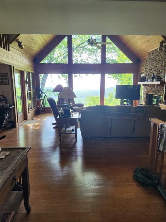1115 Wild Turkey Blf, Jasper, GA 30143 - living room with high vaulted ceiling, ceiling fan, wood ceiling with exposed beams, wood finished floors, and a stone fireplace