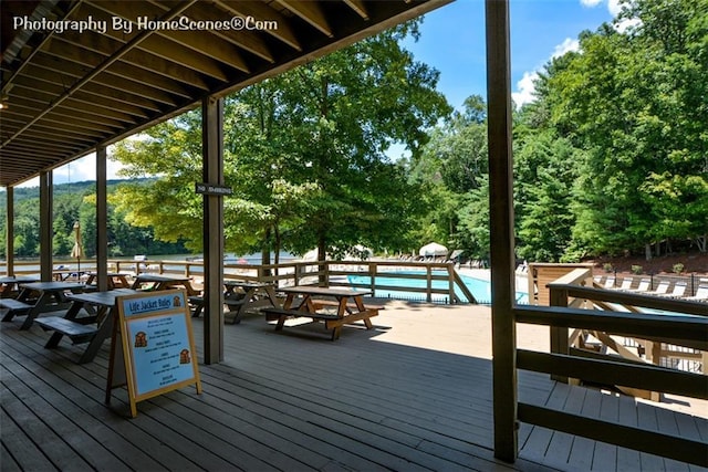 1115 Wild Turkey Blf, Jasper, GA 30143 - wooden terrace with outdoor dining space, view of scattered trees, and a community pool