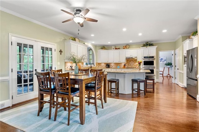 370 Fairleaf Ct, Alpharetta, GA 30022 - dining area with light wood-style floors, a ceiling fan, crown molding, recessed lighting, and french doors