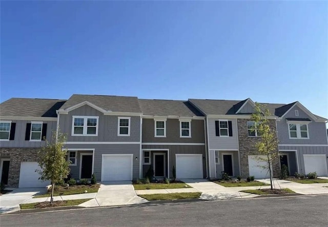 multi unit property featuring driveway, an attached garage, and board and batten siding