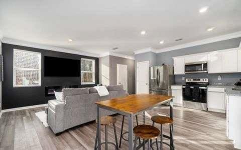 kitchen featuring appliances with stainless steel finishes, light wood-type flooring, white cabinetry, and crown molding